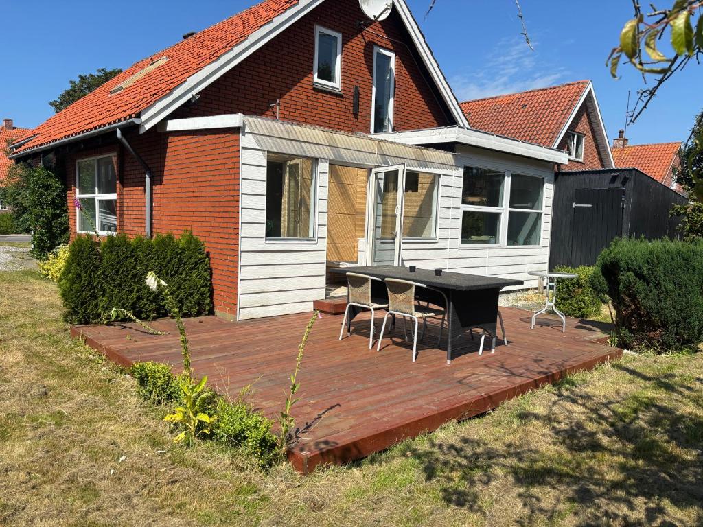 a wooden deck with chairs and a table in front of a house at Stort byhus i Lemvig in Lemvig
