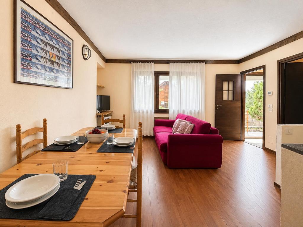 a living room with a table and a red couch at Hostdomus - B4-03 in Grange Sises