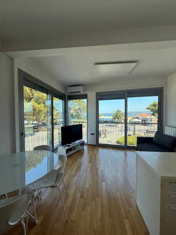 a living room with a glass table and a television at Koper Sea Apartment in Koper