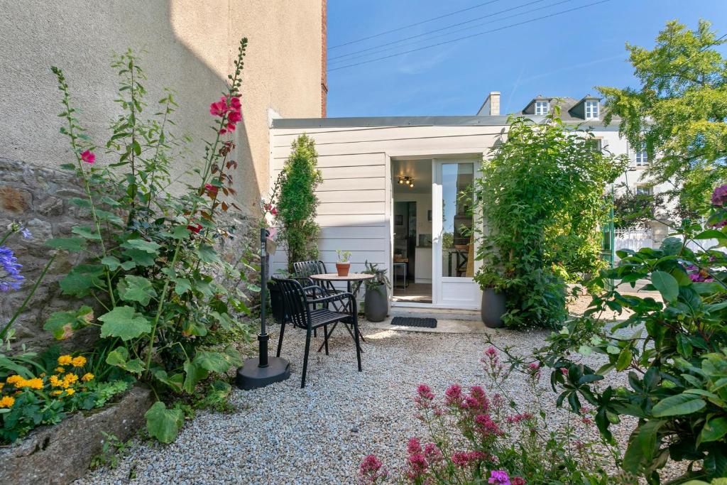 a garden with flowers and a table and chairs at Le Petit Bécot De Paimpol in Paimpol