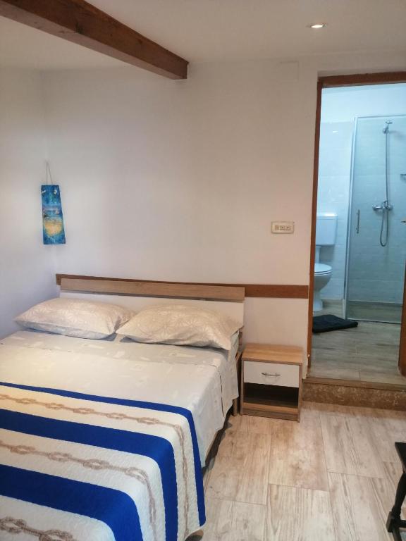 a bedroom with a bed and a bathroom with a shower at Cozy room in Pula