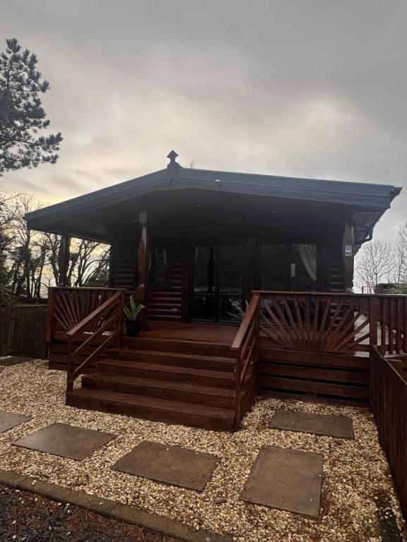 a house with a large deck with a black roof at 87 Loch Murray in Creetown