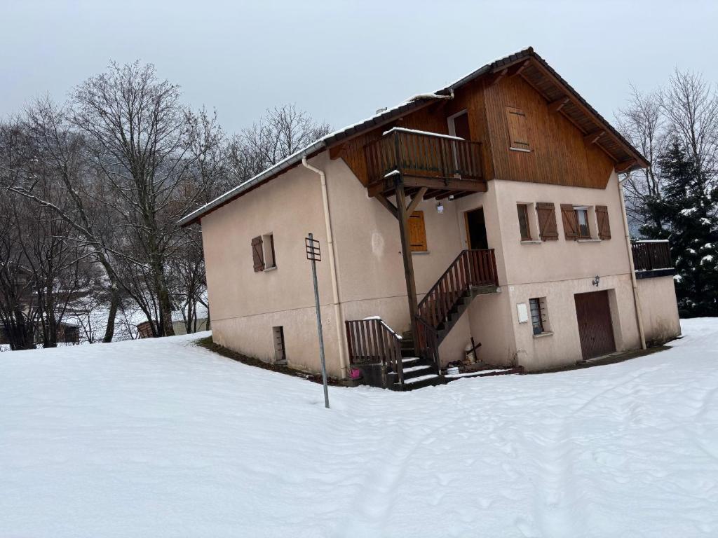 a house in the snow with a snow covered yard at House surrounded by creek in La Bresse