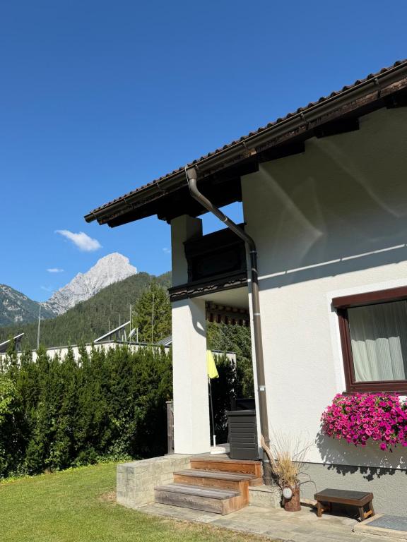 a white house with a window and pink flowers at Leischerei in Hinterstoder