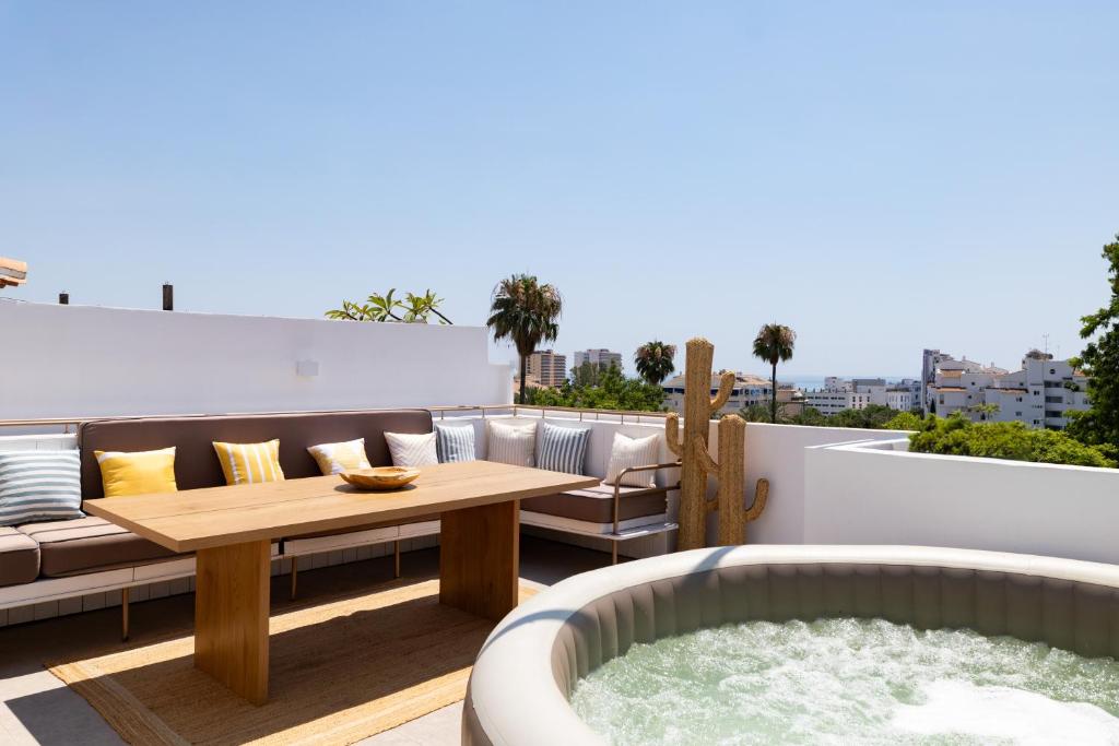 a patio with a table and a tub on a balcony at Villa Cobo in Torremolinos