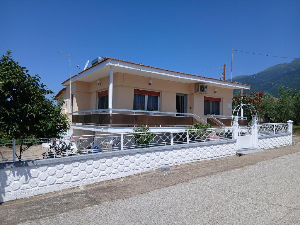 a house with a white fence in front of it at Chrysafenia's House in Mandrákion