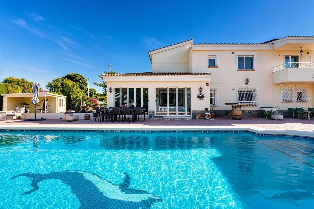 a house with a swimming pool in front of a house at Villa de Golf Hoyo 19 in Busot