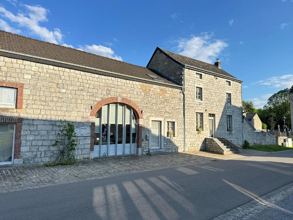 a large brick building with a large window at Authentique gite de village in Hotton