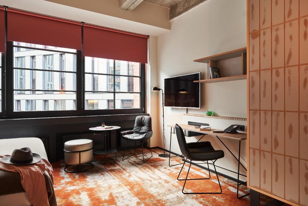 a room with a desk and two chairs and a table at hood house in Hamburg