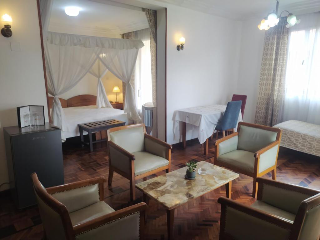 a living room with a bed and a table and chairs at Ivotel in Antananarivo