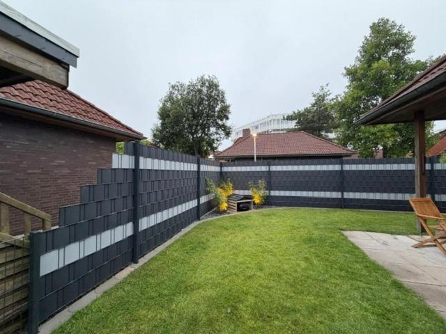 a fence in the backyard of a house at Lucys Bungalow in Butjadingen