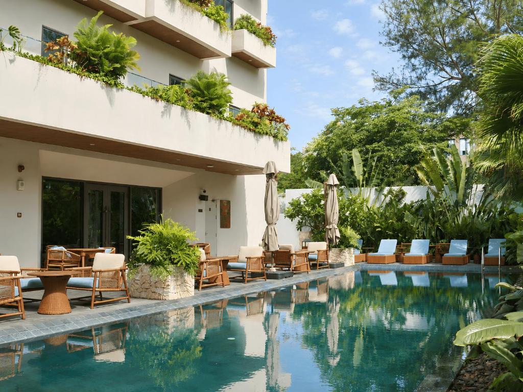 a hotel with a swimming pool with chairs and tables at Iconic Long Hai Hotel in Long Hai