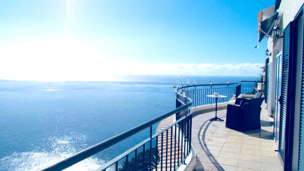 a view of the ocean from the balcony of a building at Casa Serena Apartments in Arco da Calheta