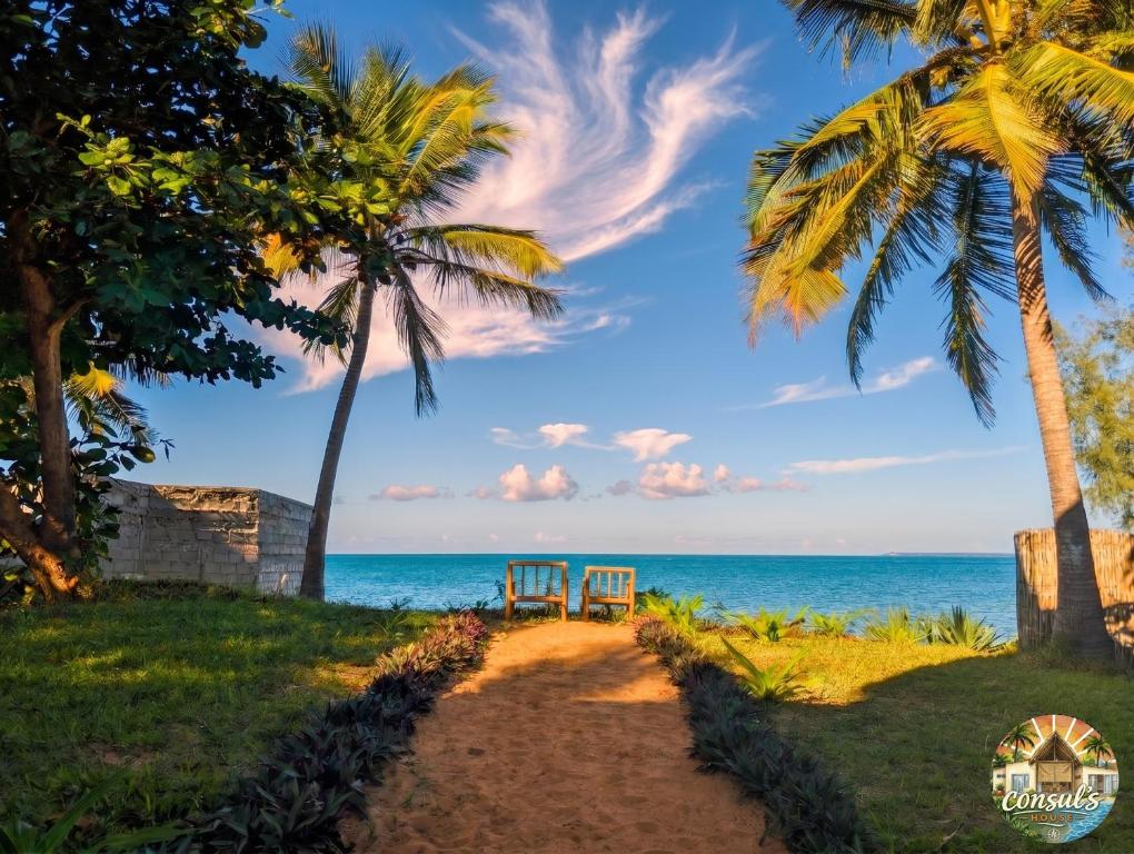 two chairs on the beach under palm trees at Consul's House Vilanculos in Vilanculos