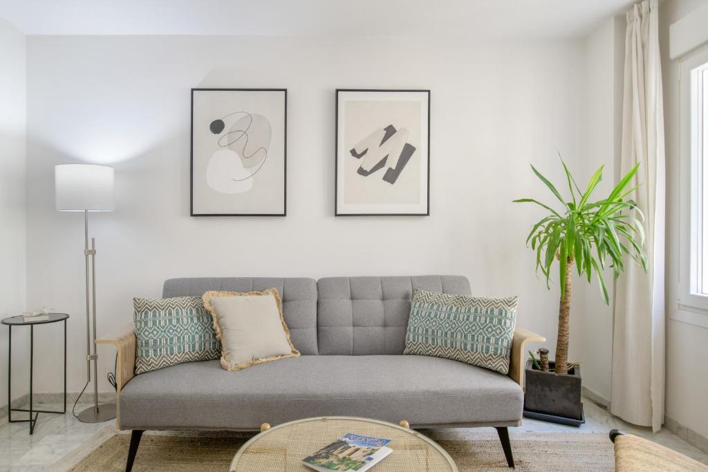 a living room with a couch and three pictures on the wall at Vicente Espinel Apartment in Ronda