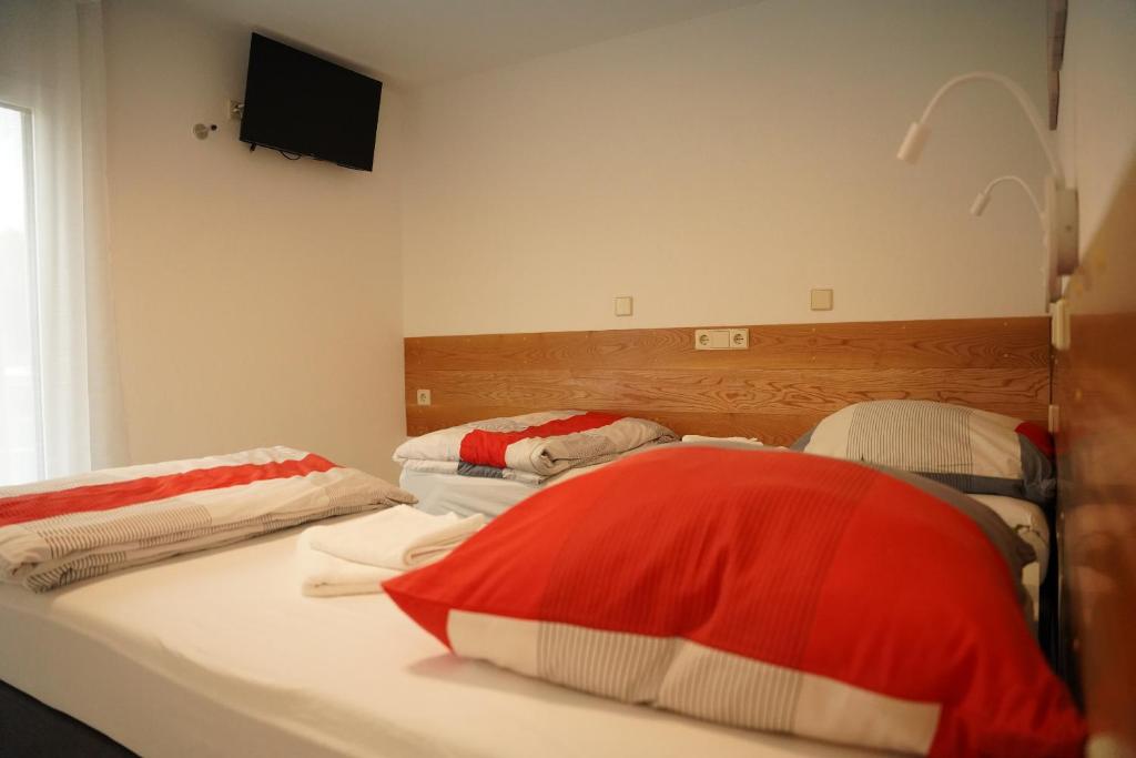 a bedroom with two beds and a tv on the wall at FeWo Reutlingen Ganghoferstr in Reutlingen