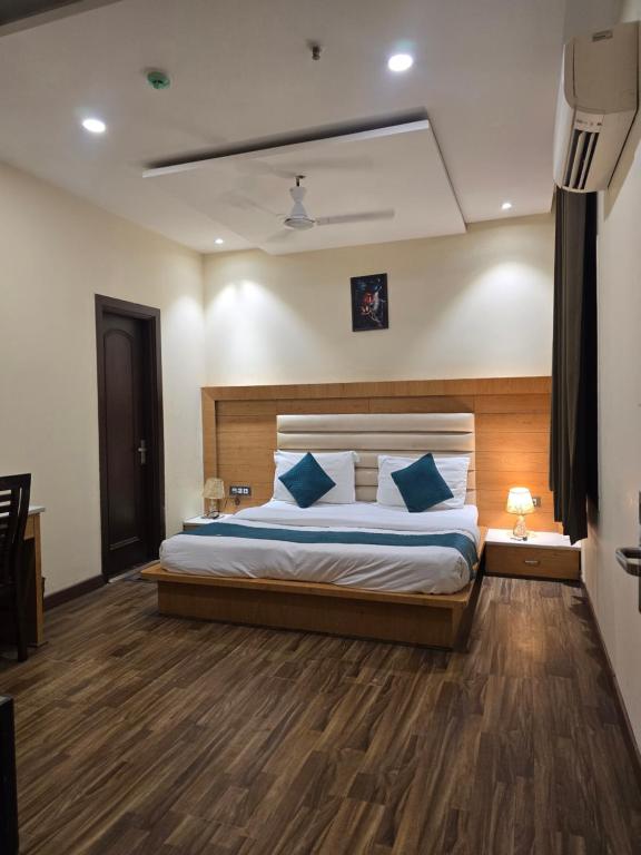 a bedroom with a large bed with blue pillows at my divine hotel in Amritsar