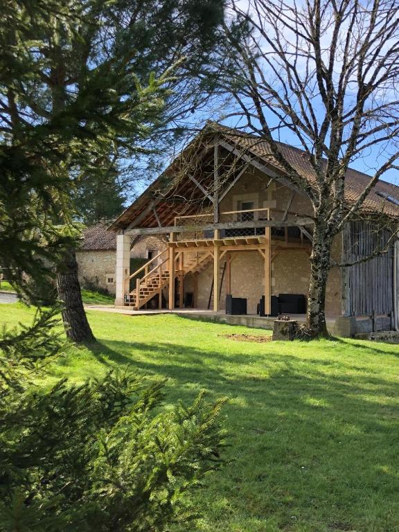 a large building with a porch on a grass field at Gîte 4 personnes in Brantôme