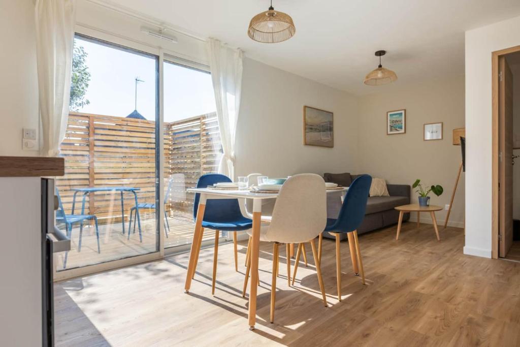 a kitchen and living room with a table and chairs at L'Écume - Cocon breton avec terrasse in Saint-Avé
