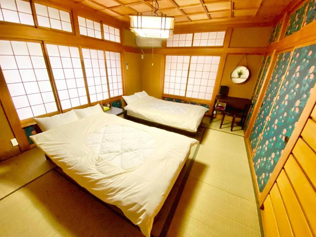 a bedroom with two beds in a room with windows at ParkView SAKURA in Aomori