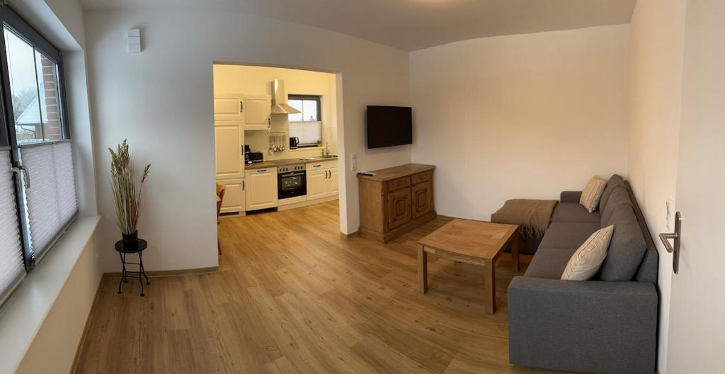 a living room with a couch and a table at Ruhig wohnen in Hüttblek in Hüttblek