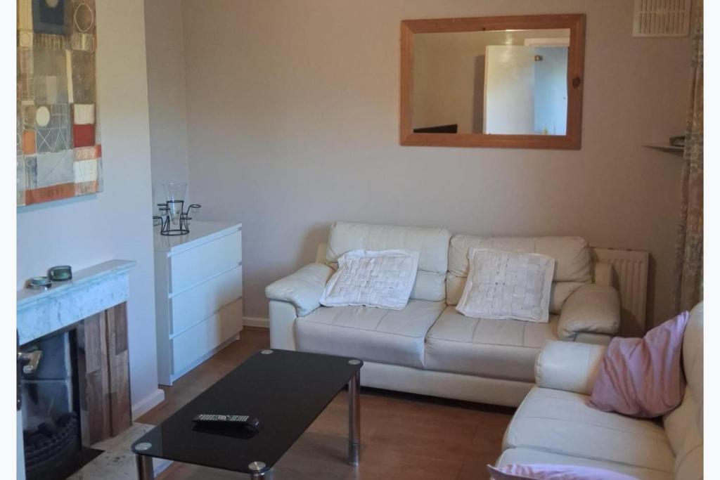 a living room with a white couch and a mirror at North Dublin 2-Bed House Sleeps 4 in Dublin