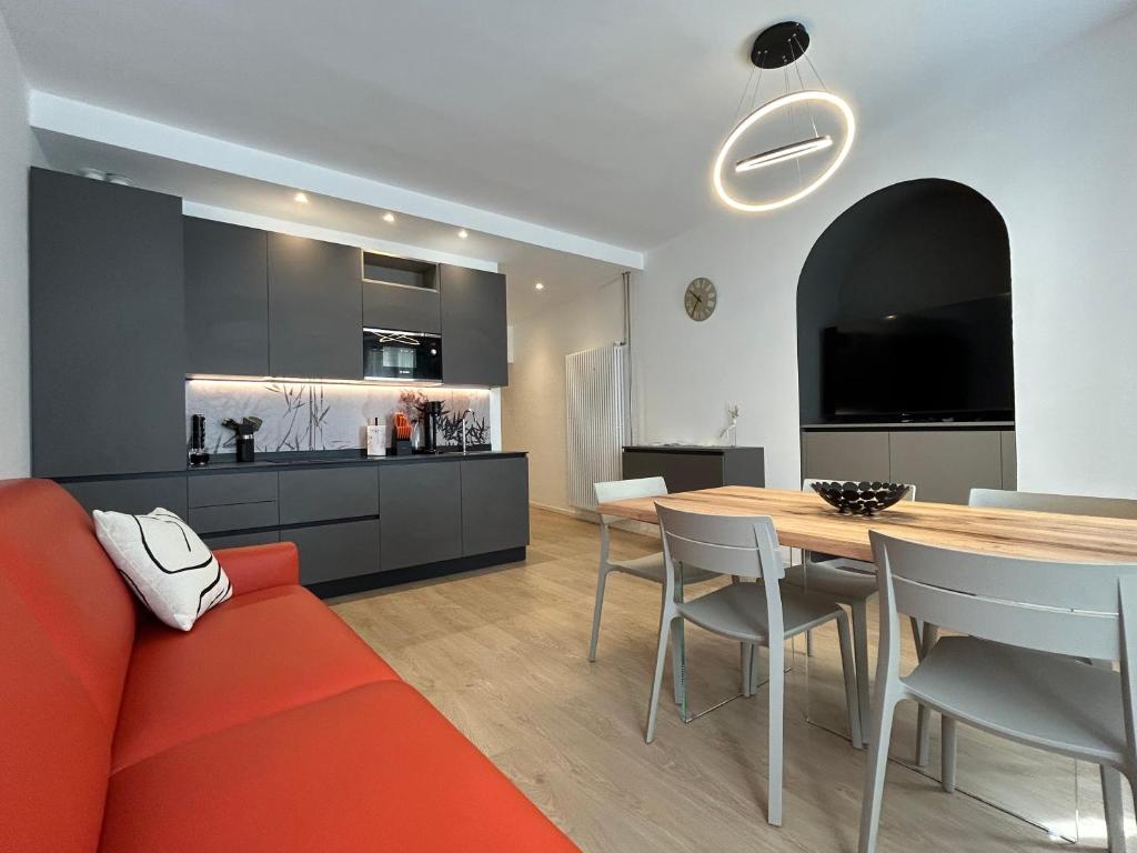 a kitchen and dining room with a red couch and a table at Rivacentro 4 in Riva del Garda