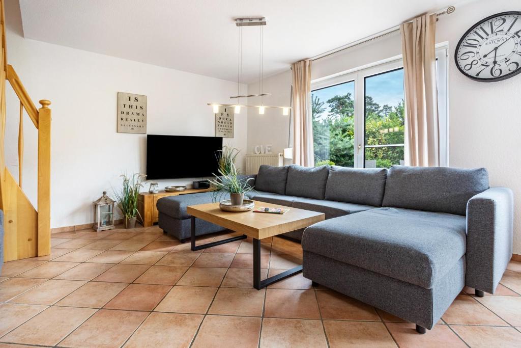 a living room with a couch and a table and a clock at Haus 29 in Röbel