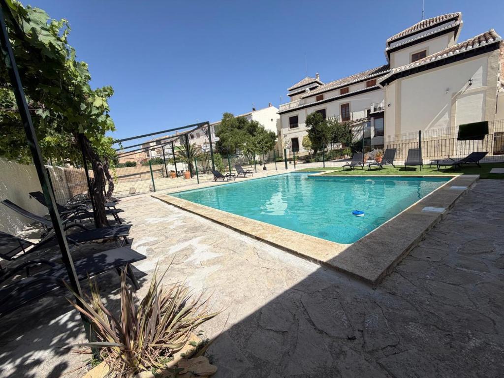 a swimming pool in front of a building at Almaterra Apartamentos Turísticos in Huéscar