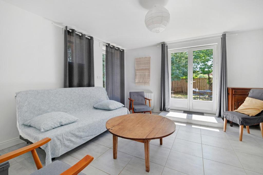 a living room with a couch and a table at Gite Du Cerisier - Varennes in Varennes