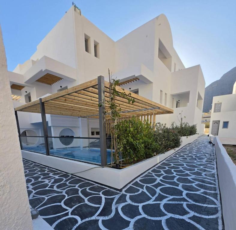 a villa with a swimming pool and a house at Angelo Boutique Hotel Santorini in Perissa
