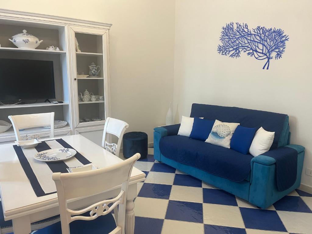 a living room with a blue couch and a table at Dimora Patrizia in Scario