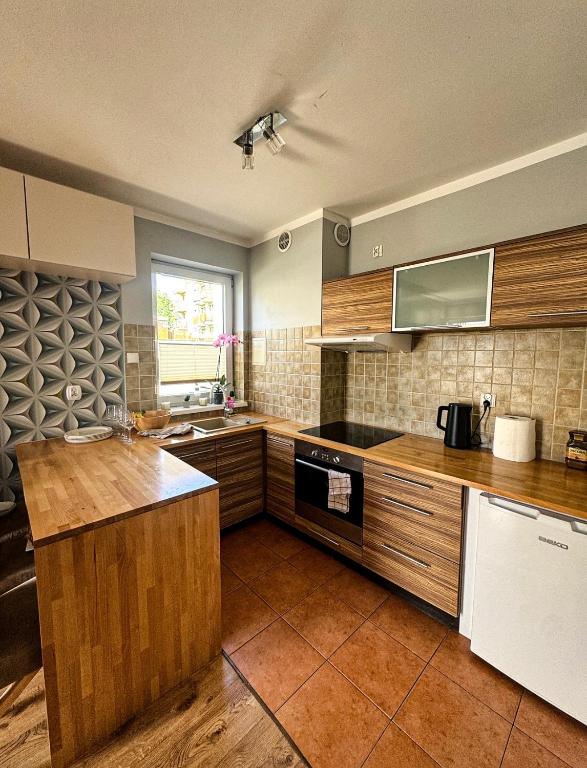 a kitchen with wooden cabinets and a counter top at The Third Six in Świnoujście