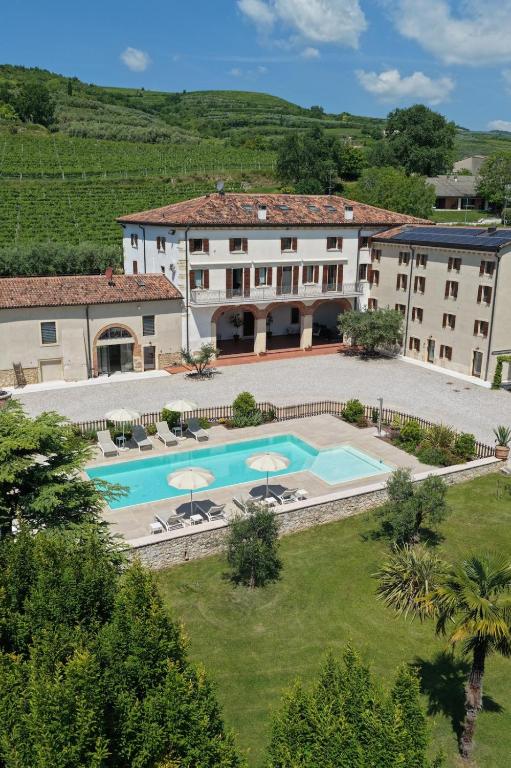 an aerial view of a hotel with a swimming pool at VerdeOlivo 1876 - Apartments & Pool in Mezzane di Sotto