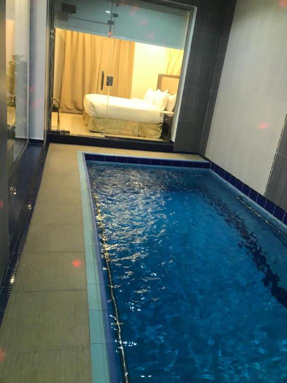 a swimming pool in a hotel room with a bed at شاليهات رميس in Abha