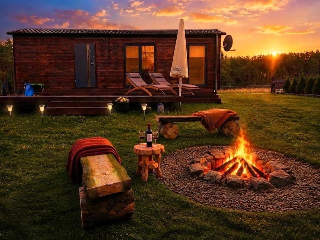 a fire pit in a yard next to a house at Osada Rolbik in Leśno