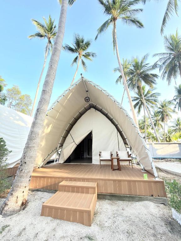 a tent on the beach with palm trees at Umbrella tree เต้ทน์ in Nathon Bay