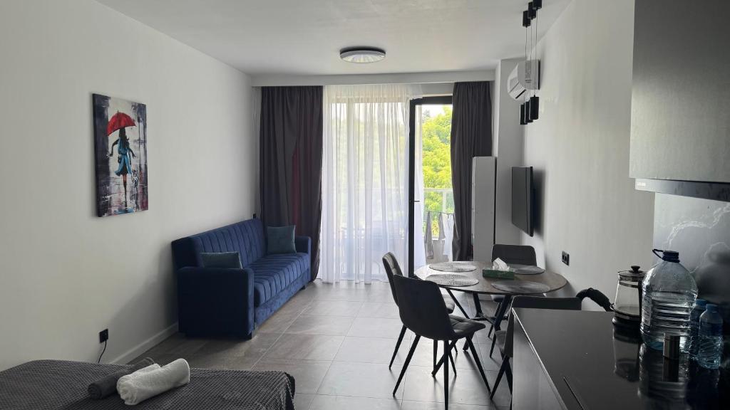 a living room with a table and a blue couch at Bamboo Beach 358 in Ts'ikhisdziri
