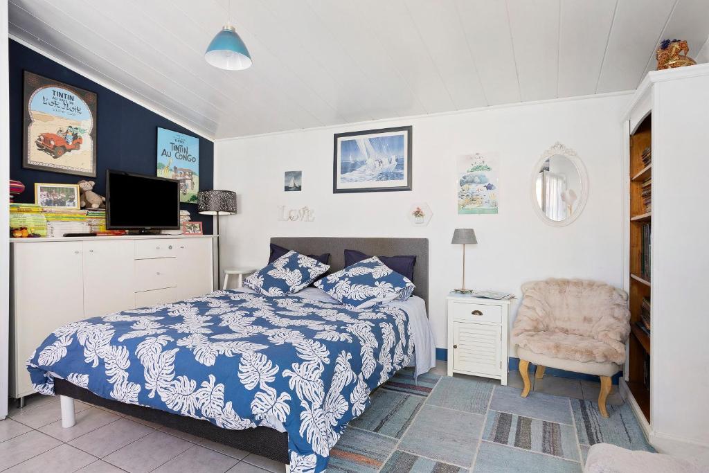 a bedroom with a blue and white bed and a chair at Chambre d'hôte Lajarrieleduc in La Jarrie