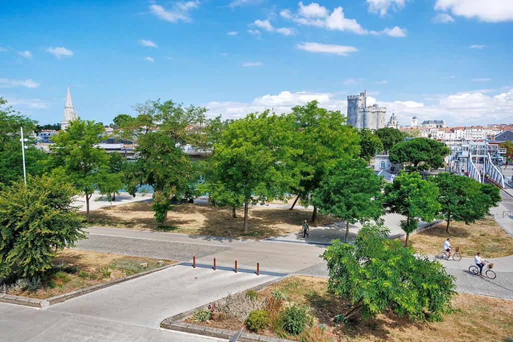 a park with trees and people riding bikes on a street at Les 2 tours La Rochelle in La Rochelle