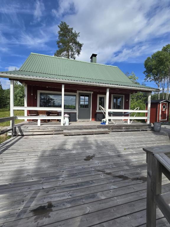 a building with a wooden deck with a porch at Revontulet ZH Tuliaalto Moki in Pieksämäki
