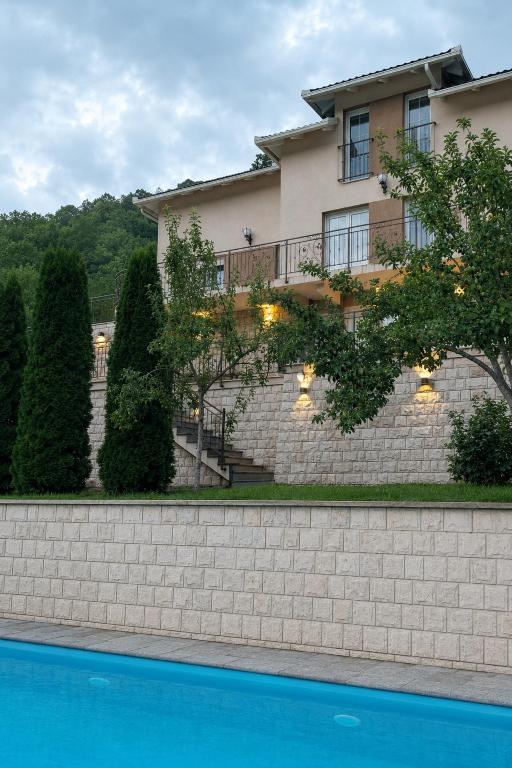 a house with a swimming pool in front of it at Villa AS sa bazenom na Jablaničkom jezeru in Konjic