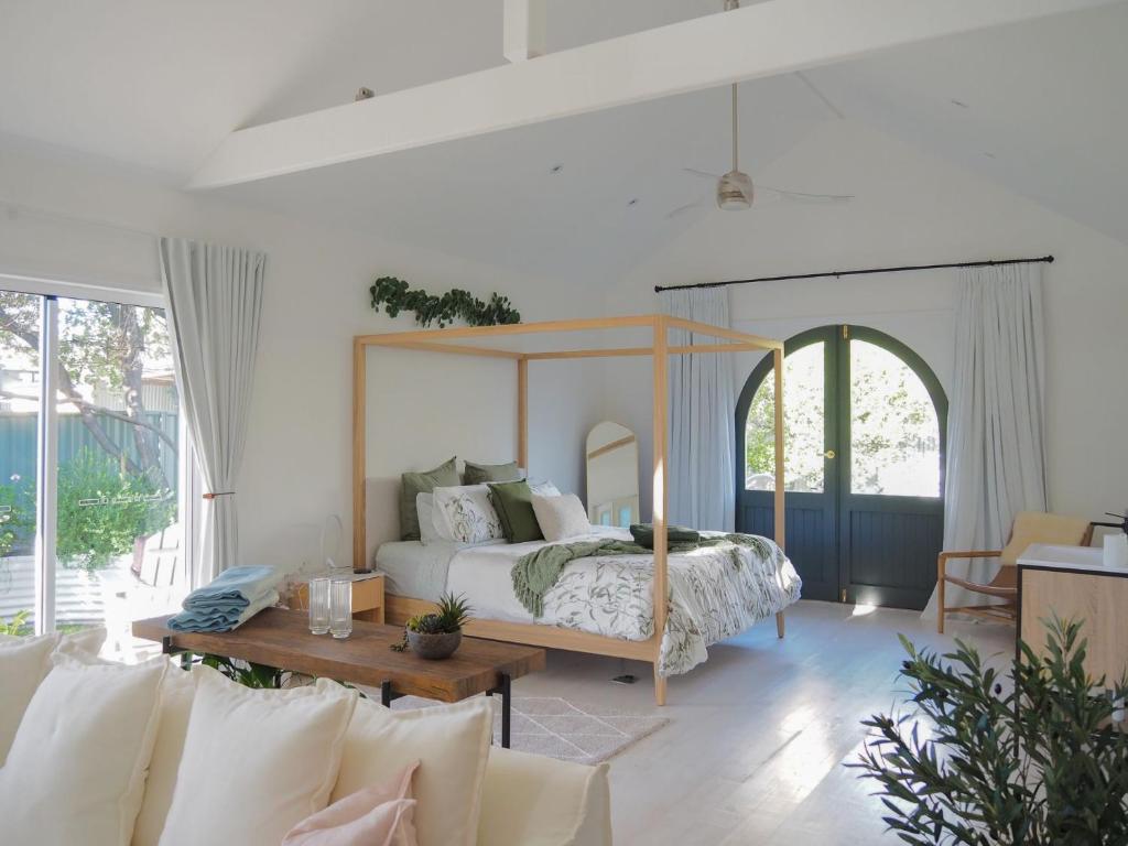 ein Schlafzimmer mit Himmelbett und Tisch in der Unterkunft Lemon Tree Studio in Beechworth