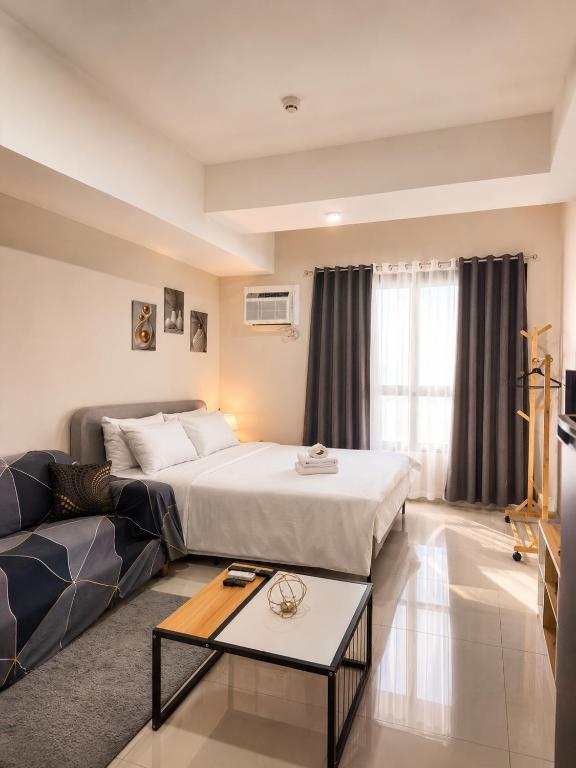 a hotel room with a bed and a couch at Jtower residences mandaue 12th flr in Mandaue City