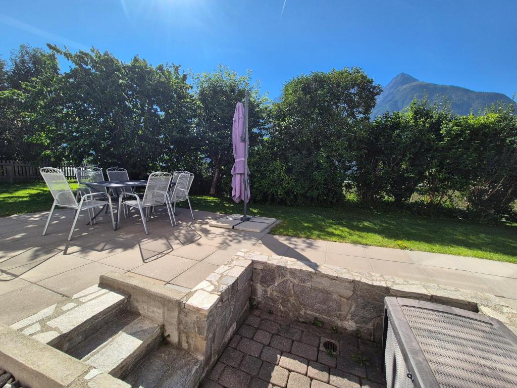 a table and chairs and an umbrella on a patio at FeWo Aquileia Scuol, Gratisparken, Terrasse, Wifi, flexible Zimmerwahl, Familien in Scuol