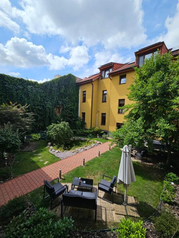 a patio with an umbrella and chairs and a building at Penzión Hradbová Old Town Residence & SPA in Košice