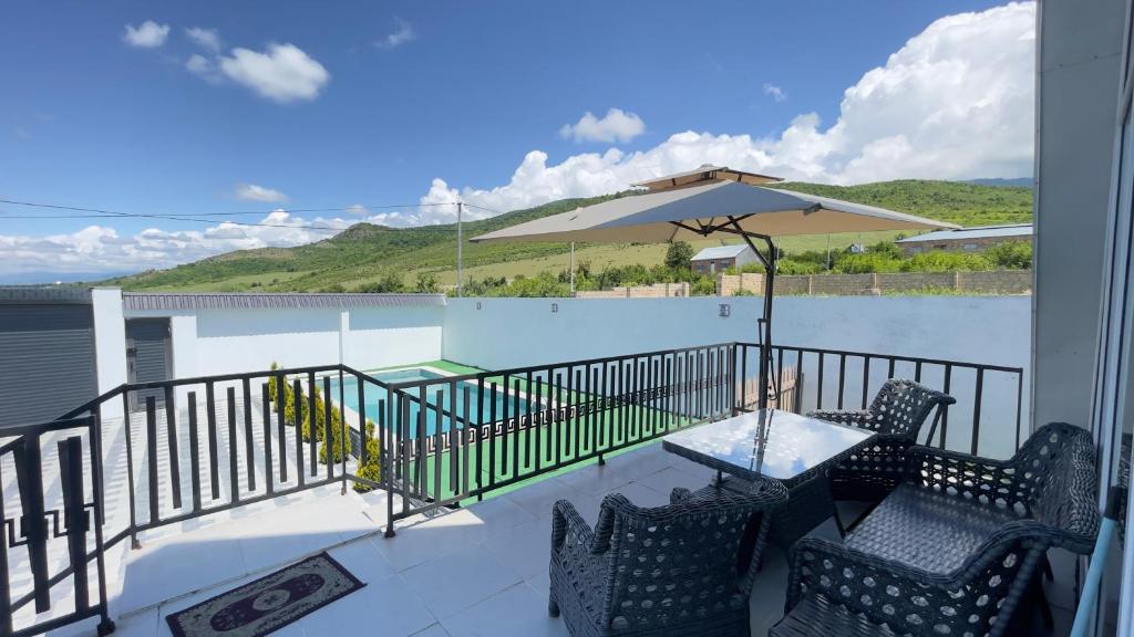 a patio with a table and chairs and an umbrella at AkbA-Frame4 in İsmayıllı