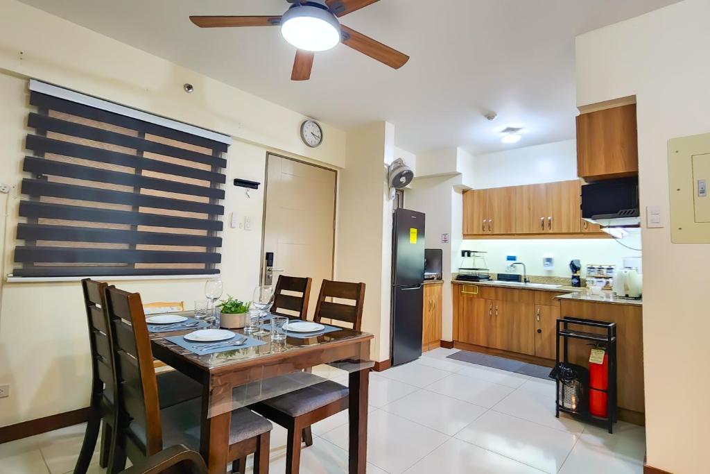 a kitchen and dining room with a table and chairs at 2BR Fully Air-Conditioned Staycation with Parking in Manila