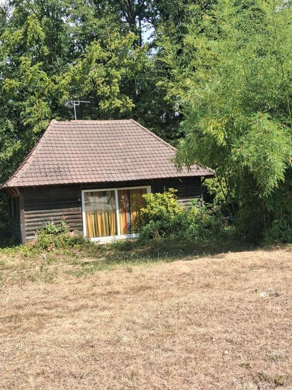 a small house with a window in a field at Charmant chalet in Auffargis