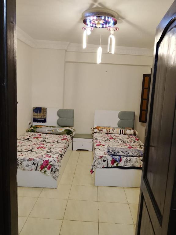 a room with two beds and a ceiling at White Pearl Apartment in Alexandria